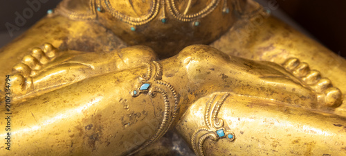 Golden Buddha statue detail with turquoise stones