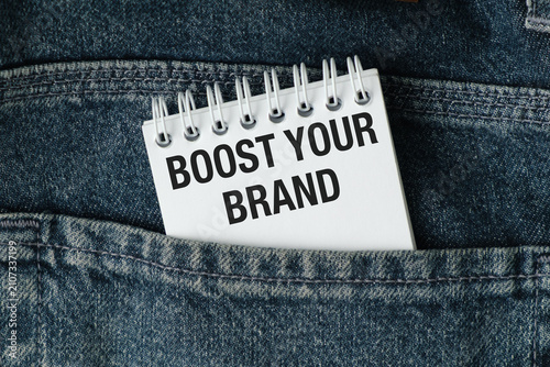Note peeking from jeans pocket. Bold text reads: Boost Your Brand. Denim texture adds casual, relatable vibe.