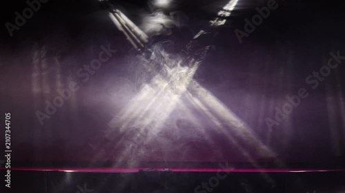 The stage of the night club illuminated by spotlights and smoke