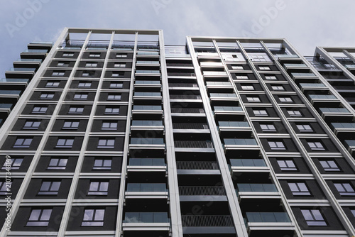 Photography modern apartment building stands tall against the sky with many floors and windo