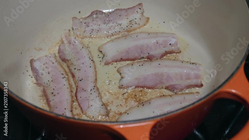 Peppered bacon rendering in an enameled cast iron Dutch oven