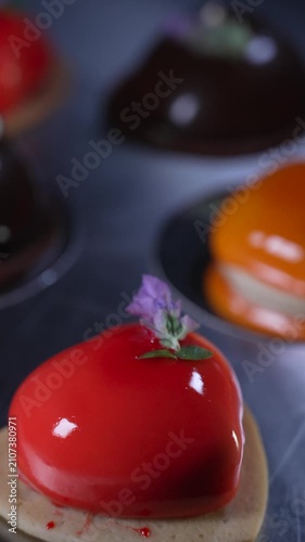 Close up of an elegant red mousse pastry featuring a beautiful shiny mirror glaze, delicately decorated with a small lavender flower, professional confectionery, cinematic food videography
