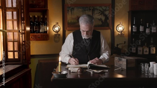 Saloon keeper writing in account ledger with dip pen