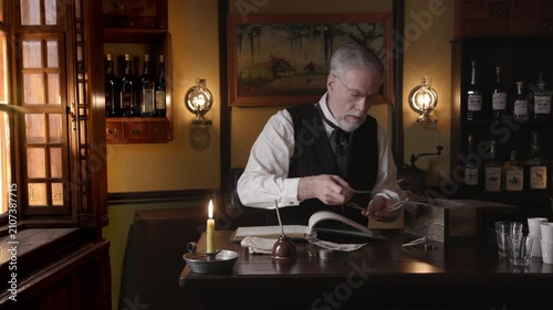 Saloon keeper puts paper money in bank bag