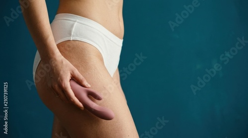Woman Holding Sex Toy Against Blue Background