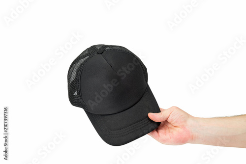 a mens hand holds a black cap by the visor on a white background