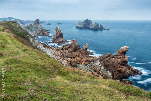 View of Costa Quebrada, in Liencres, Cantabria, Spain, with impressive rock formations sculpted by erosion and a calm sea at the end of a cloudy summer day.