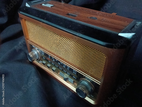 Cuadro en lienzo A vintage portable analog radio with a classic wooden cabinet, woven speaker grille, and silver tuning knobs