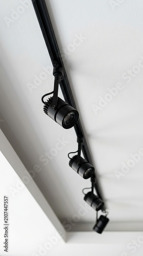 Black track lighting with spotlights mounted on a wall.