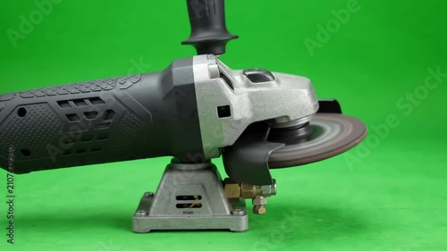 Industrial pneumatic air grinder tool with spinning disc isolated on chroma key green screen