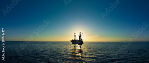 Aerial view of offshore jack up rig and offshore platform during sunset