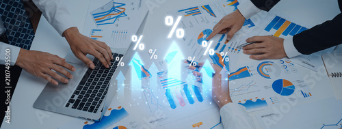 Bild auf Leinwand A team of business professionals collaborates at a desk, analyzing financial graphs and reports to inform strategic decisions and identify growth opportunities