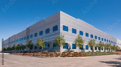 Industrial warehouse building with large blue-tinted windows under a clear sky