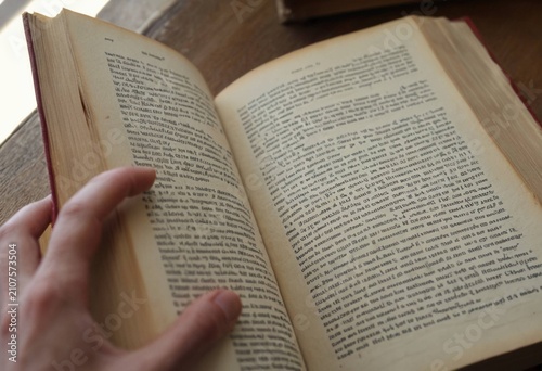 Open book with detailed text pages on a wooden surface, learning and knowledge concept