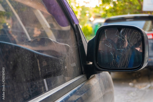 Obraz na plátne Broken side mirror glass on a dirty car close up view