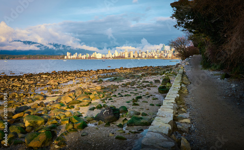 Vancouver city skyline and West End high rise buildings viewed from the waterfront path at Point Grey Park Site at Trafalgar Street across English Bay at low tide, British Columbia, Canada.