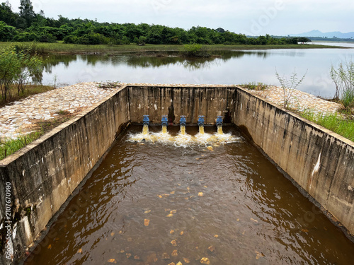 Agricultural irrigation system concrete spillway structure, showcasing rural water resource management, drainage pipes discharging inflow, reservoir hydraulics, and civil engineering