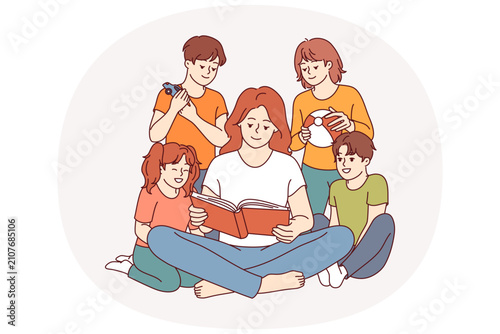 Woman kindergarten teacher reads book to children who are listening with interest to new fairy tale. Happy kindergarten students enjoying friendly atmosphere and opportunity to spend time together