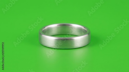 Simple silver metal band on green background
