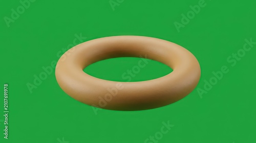 Round tan plastic ring isolated on green background