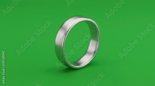 Simple silver metal band ring on green surface