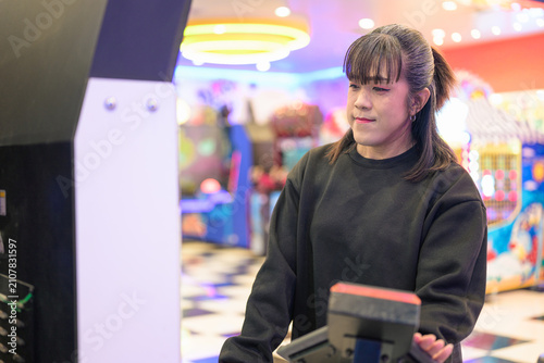 Slika na platnu Focused Woman Operating Arcade Machine in Entertainment Center