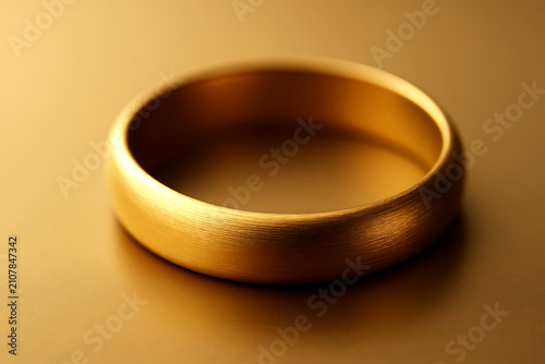 Minimal golden ring on warm background, elegant metallic jewelry concept for luxury branding and design