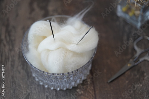 Obraz na plátně White unspun wool with felting needles in a glass vase