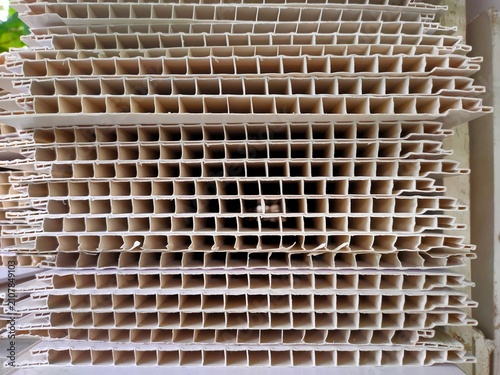 Texture of stacked white corrugated plastic sheets forming a grid.