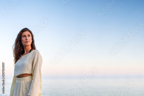 Cuadro en lienzo Young woman contemplating the vastness of the sky and calm sea, a serene moment