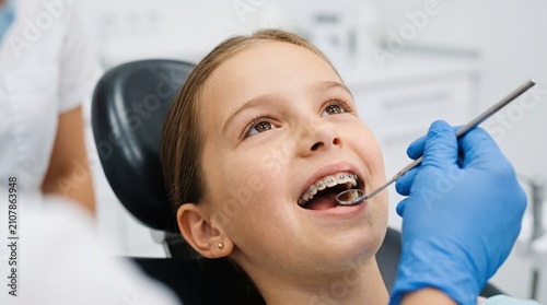 Smiling Girl with Braces Getting Dental Checkup at Orthodontist Clinic