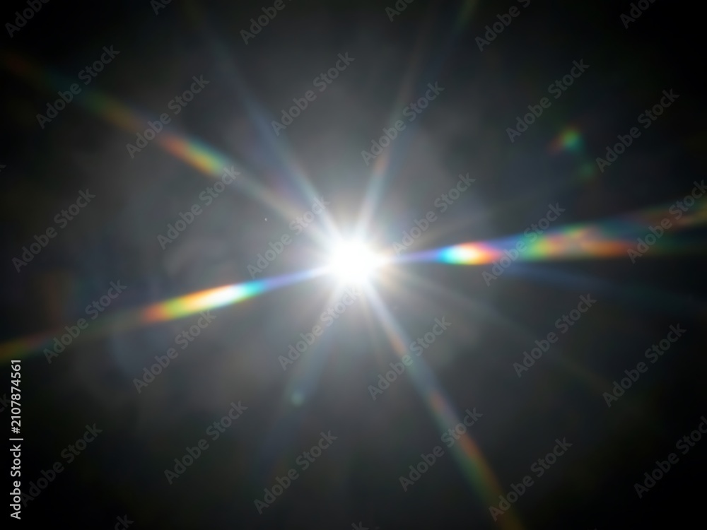 Obraz premium Bright Sunburst with Rainbow Lens Flare Across a Dark Sky.