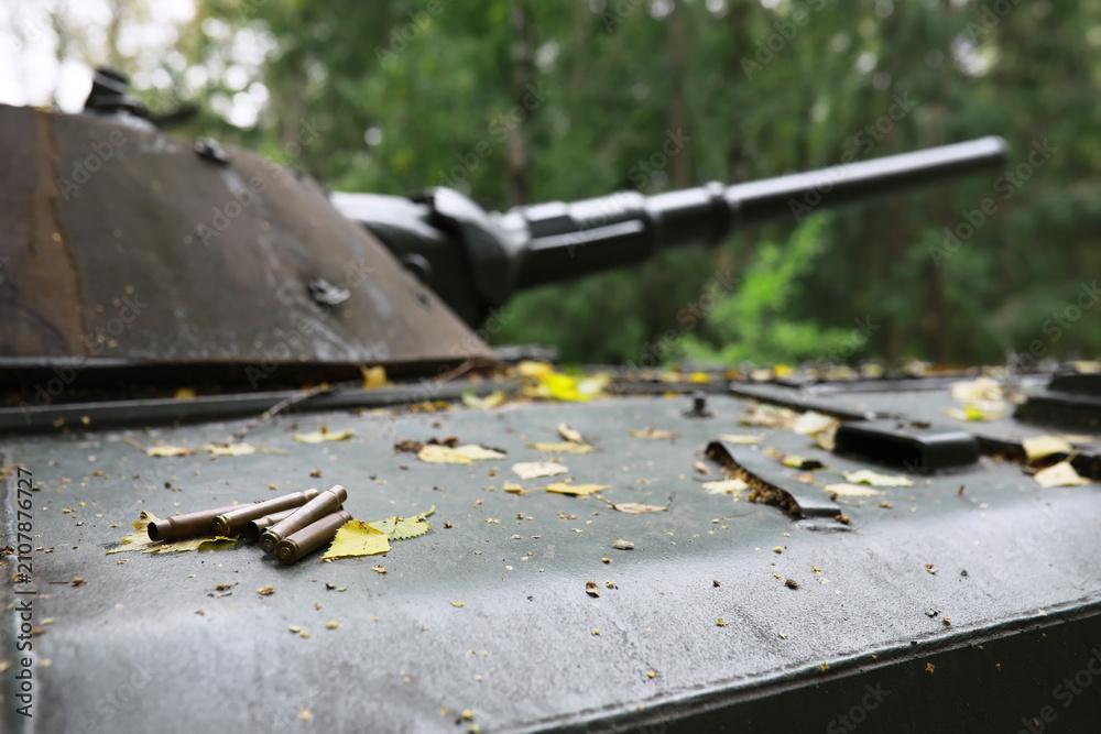 Fototapeta premium A selective focus shot of an abandoned military tank in the forest
