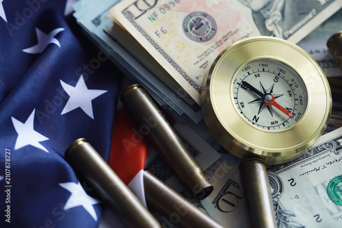 Money bill with golden Compass. Bullets and cartridge cases as a military concept. Close up US Currency and compass. business  financial idea  concept  symbol of crisis  inflation