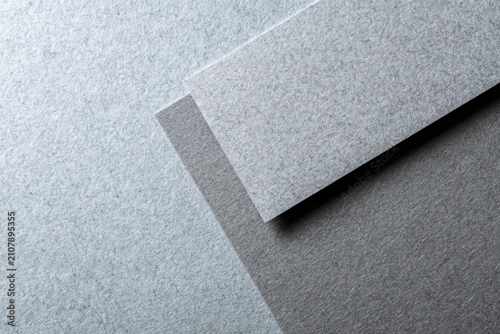 Fototapeta premium Calm grey gloss paper background with light texture and cardboard accent for layouts