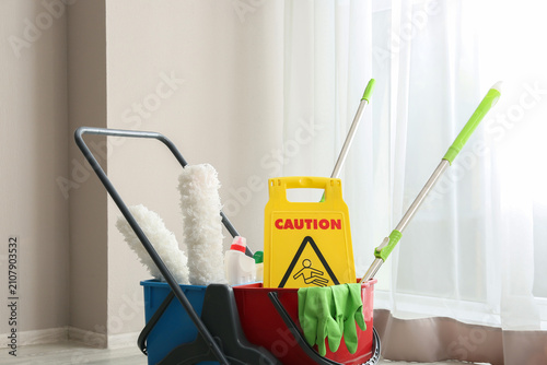 Fotografie Cleaning cart with caution wet floor sign and supplies for professional janitori