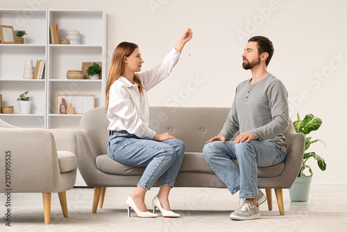 Fotografie Female psychologist with pendulum hypnotizing young man in office