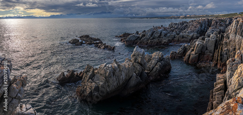 Sweeping view across Walker Bay from De Kelders toward Hermanus in the Overberg, Western Cape, South Africa, showcasing a dramatic coastal landscape, ocean, cliffs, and scenic travel destinations.