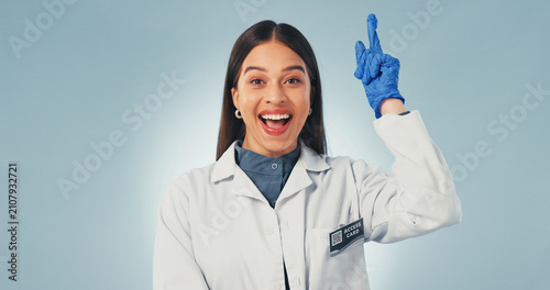 Quadro su tela Idea, science and smile with portrait of woman in studio for healthcare solution, eureka or pointing