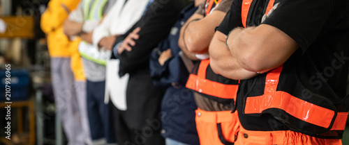 Profile view of diverse industrial team standing with arms crossed