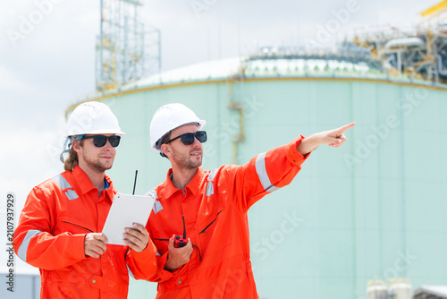 Two male engineers discussing site inspection and using tablet in works
