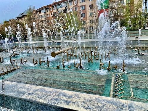 Photography Gran fuente urbana con múltiples chorros de agua en movimiento frente a edificio