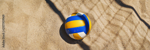 Beach volleyball court with a volleyball ball placed in the sand.