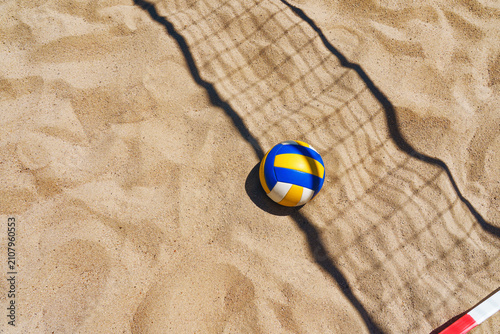 Beach volleyball court with a volleyball ball placed in the sand.