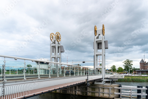 Картината върху платно Kampen, Netherlands – June 6, 2026: The modern Stadsbrug crossing the IJssel River features twin lifting towers, glass railings and contemporary engineering beneath dramatic storm clouds