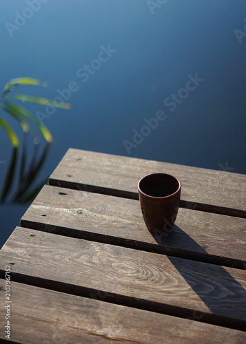 clay mug on a wooden pier near the lake