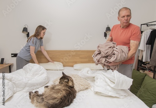 Canvas Print Man and woman stuffing duvet into fresh cover