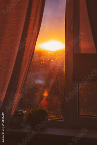Sunrise peeking through a cozy window, casting warm light into the quiet room