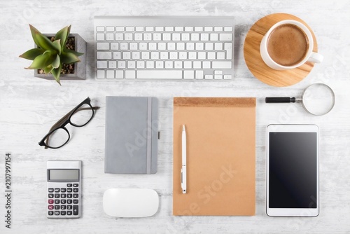 Minimal modern workspace featuring laptop, coffee cup and office accessories on a clean wooden desk. Suitable for business, remote work and productivity concepts.