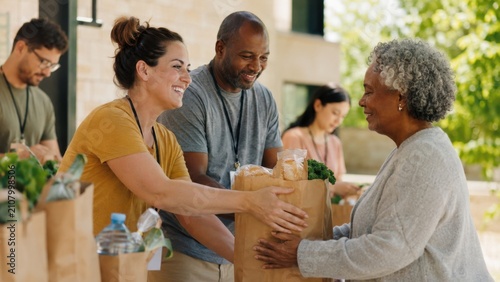 Volunteers distributing grocery donation bags to grateful community members during local food assistance event